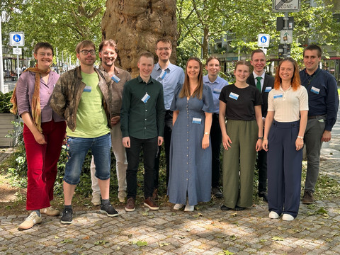 Gruppenfoto der jungen Synodalen. Elf Personen stehen vor einem Baum und lächeln in die Kamera.