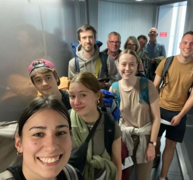 Jugendgruppe aus Lauter und Erwachsene aus der Gemeinde lächeln in die Kamera. Sie sind auf dem Weg ins Flugzeug.