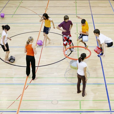 Jugendliche in einer Sporthalle, von oben fotografiert 