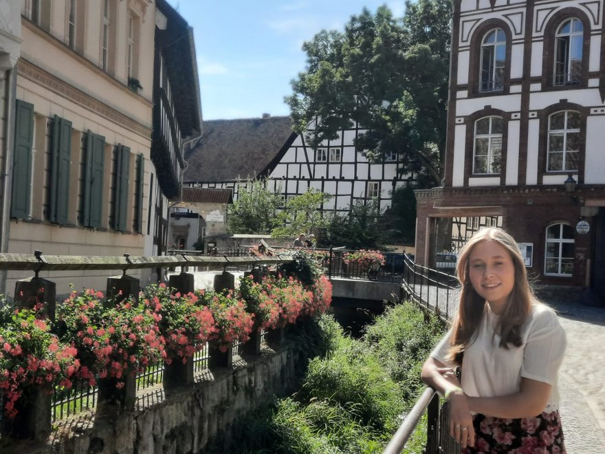 Annika lehnt lächelnd an einem Geländer.