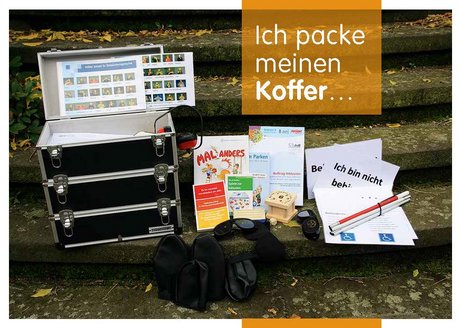 Aktionskoffer Inklusion Koffer mit ausgebreiteten Materialien zum Thema Inklusion