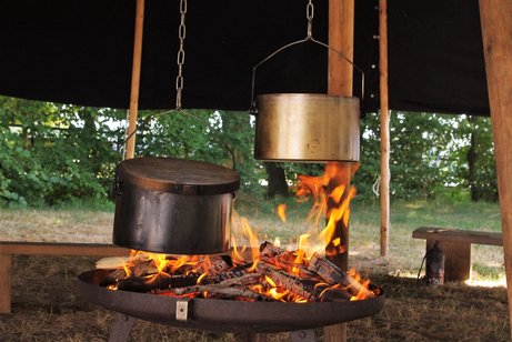 Töpfe über großem Lagerfeuer 