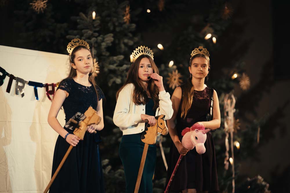 Drei junge Frauen mit Kronen und Hobbyhorses.