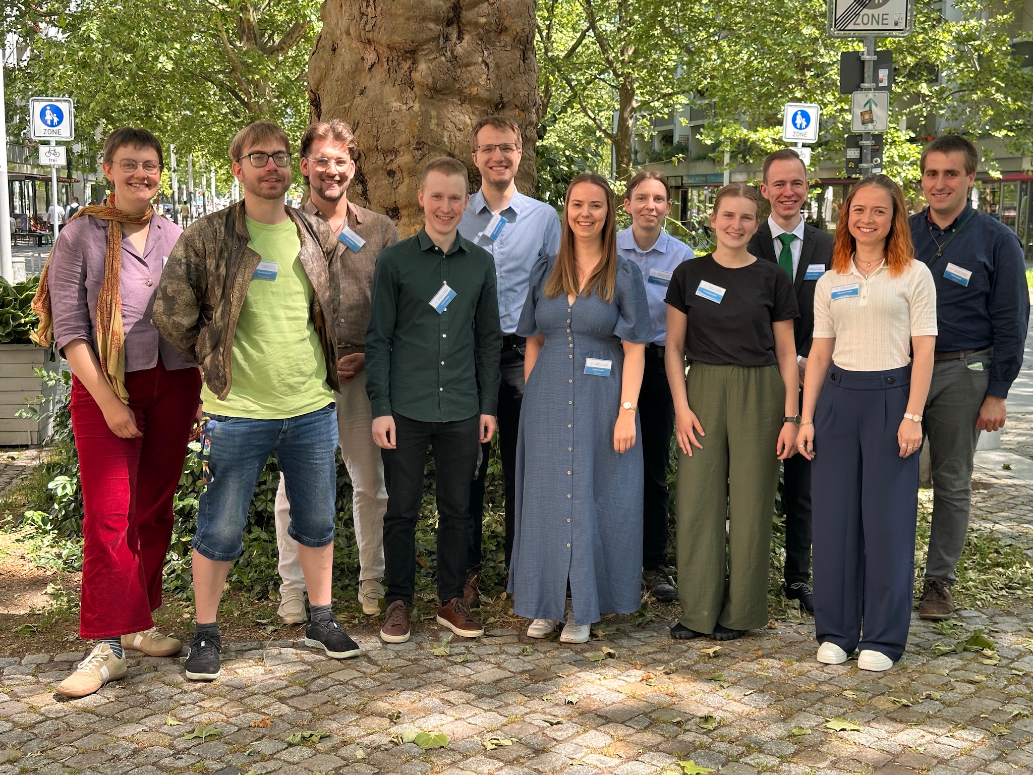 Gruppenfoto der jungen Synodalen. Elf Personen stehen vor einem Baum und lächeln in die Kamera.