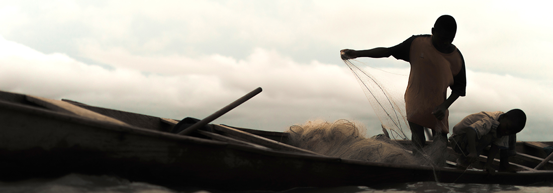 Junge auf einem kleinen Boot mit Fischernetz